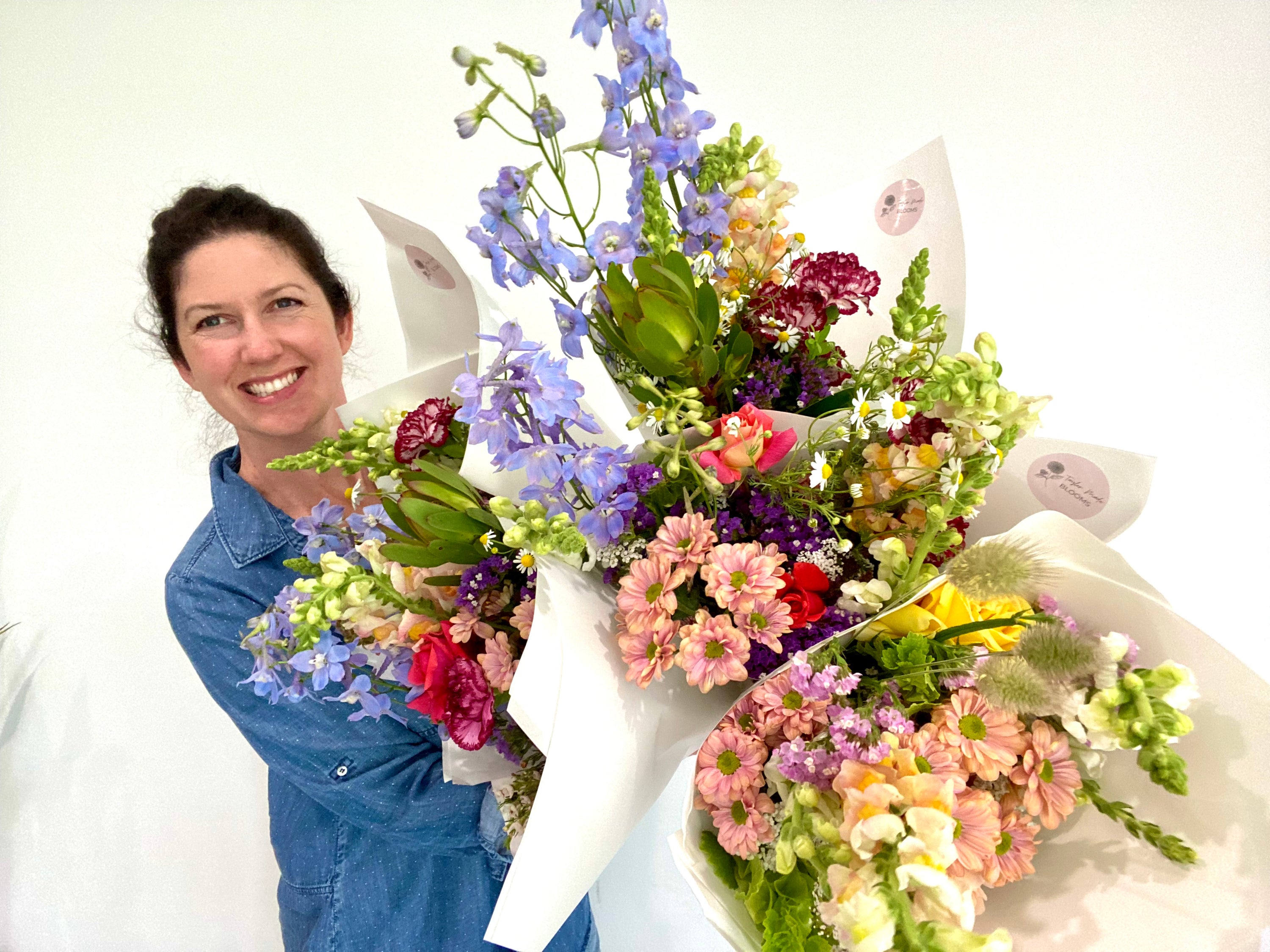 Ellie Taylor of Taylor Made Blooms holding up an armfull of her own flower creations at her store Taylor Made Blooms Echuca Moama
